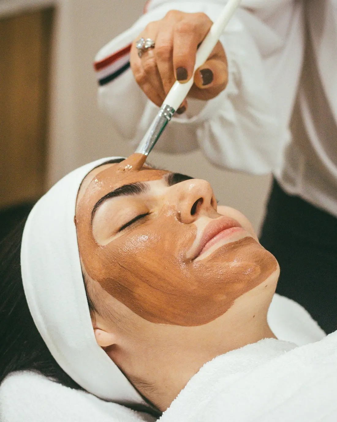 Donna che riceve un trattamento con maschera facciale in un centro estetico
